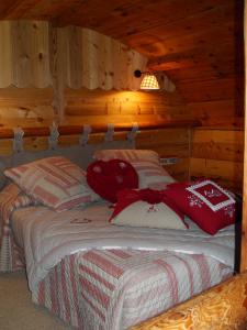 1 dormitorio con 1 cama en una cabaña de madera en Le Grenier, en Saint-Paul-en-Chablais