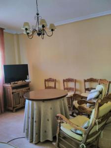 ein Wohnzimmer mit Tisch und Stühlen und einem Fernseher in der Unterkunft Villa Rural Campillo de Arenas in Campillo de Arenas