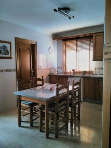 eine Küche mit einem Tisch und Stühlen sowie einem Tisch und einer Küche in der Unterkunft Villa Rural Campillo de Arenas in Campillo de Arenas