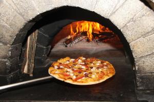 una pizza sta cuocendo in un forno di mattoni di Hotel Pawan's Palace a Pushkar Altre 17 foto