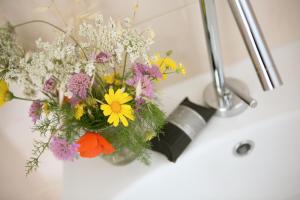 a vase of flowers sitting on a sink at Antica Masseria Ficazzana - Tenuta in Marina di Pescoluse