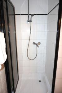 a shower with a shower head in a bathroom at Artus Hotel in Düsseldorf +19 photos