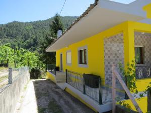 a yellow house with a fence in front of it at Quinta Machado Da Pedra Bela in Geres