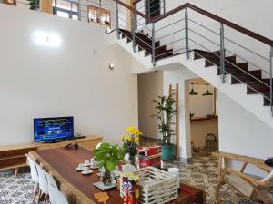 a living room with a table and a staircase at Tia Du Villa Homestay in Da Lat