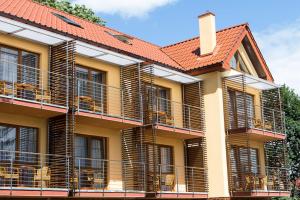 un edificio con balcones y techo rojo en Willa Florek, en Rewal