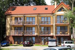 a large building with cars parked in front of it at Willa Florek in Rewal