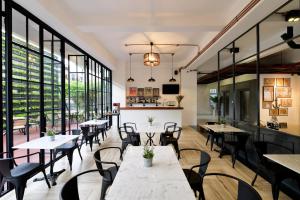 a restaurant with tables and chairs and large windows at Ruenthip Pattaya in North Pattaya