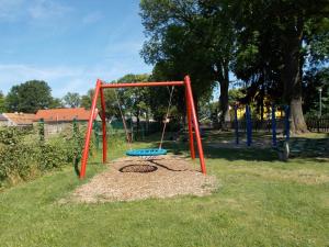 a playground with a swing set in the grass at Ferienhaus am Langen See in Heidesee