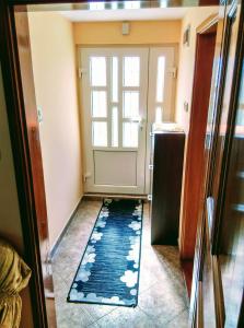 un pasillo con una puerta con una alfombra delante en Apartman Anastasija, en Žabljak