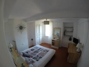 Le Thoronet Appartement في لو ثوروني: غرفة نوم بسرير ومكتب ونافذة
