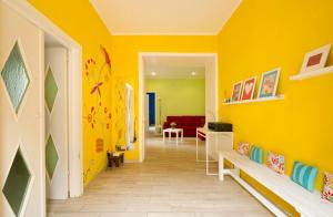 a hallway with yellow walls and a room with a couch at Casetta di Cleo in Papigno
