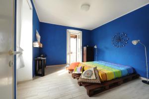 Papigno的住宿－Casetta di Cleo，一间卧室设有蓝色的墙壁和一张带长凳的床