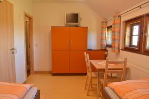 Zimmer mit einem Tisch und einem Schrank mit einem TV. in der Unterkunft Klügelhütte in Kurort Altenberg