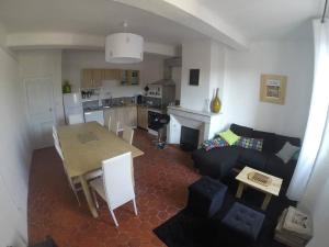 Le Thoronet Appartement في لو ثوروني: غرفة معيشة مع أريكة وطاولة ومطبخ