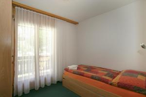 Schlafzimmer mit einem Bett und einem Fenster in der Unterkunft Residenz Darianne 21 in Leukerbad