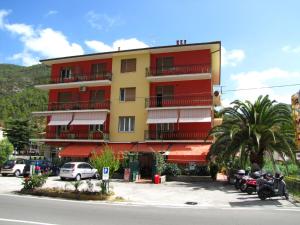 a red and yellow building with motorcycles parked in a parking lot at Tramontiemare in Casarza Ligure