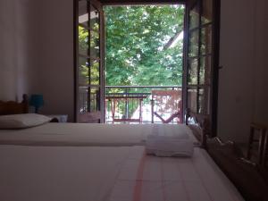 a bedroom with a bed and a large window at Paparizou Apartments in Kokkino Nero