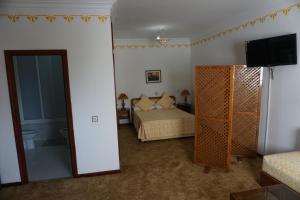 ein Schlafzimmer mit einem Bett und einem TV in einem Zimmer in der Unterkunft Hotel Zelis in Asilah