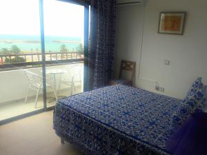 a bedroom with a bed and a window at Hotel Zelis in Asilah