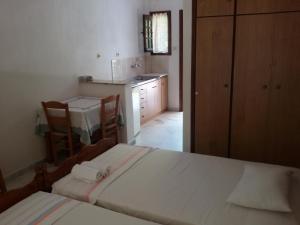 a bedroom with a large bed and a kitchen at Paparizou Apartments in Kókkinon Nerón