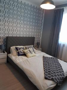 een slaapkamer met een bed met een grijze en witte muur bij Pokoje Morska Syrenka in Stegna