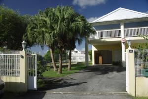 una casa con un cancello e una palma di Résidence le Belvedere de Gissac a Sainte-Anne