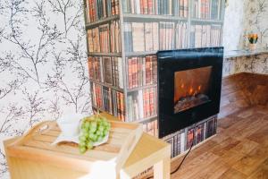 a living room with a fireplace and a book shelf with books at Spa Glamping in Kirikumõisa