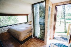 a bedroom in a tiny house with a large window at Spa Glamping in Kirikumõisa