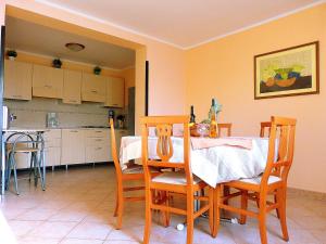 een eetkamer met een tafel en stoelen en een keuken bij Apartment Oliva in Pula