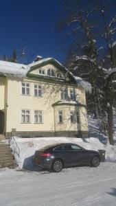 a car parked in front of a house in the snow at Olivin Kytlice in Kytlice