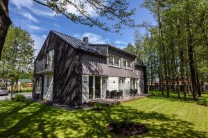 a house with a black roof at Sakalo 44 in Palanga