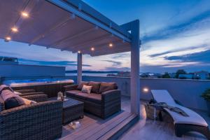 a patio with two couches on a deck at night at Apartments Sun Resort Nikolina in Bibinje