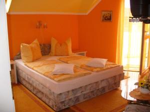 A bed or beds in a room at Caty Vendégház