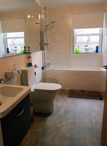 a bathroom with a tub and a toilet and a sink at Yvi's 2Bedroom 2Bathroom Apartment in Inverurie