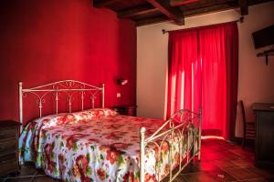 una camera rossa con letto e tende rosse di Agriturismo Aurea a Torretta