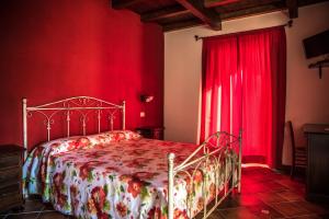 a red bedroom with a bed and red curtains at Agriturismo Aurea in Torretta