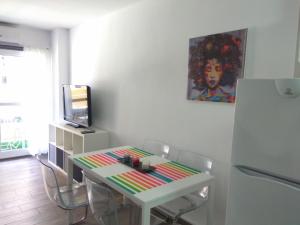 ベナルマデナにあるEstudio Minerva 241のテーブル、椅子、テレビが備わる客室です。