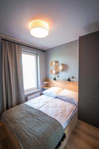 a bedroom with two beds and a large window at Apartamenty Sea Stars in Ustronie Morskie