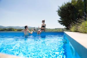 ドブロボにあるVilla EVAのスイミングプールに座って2名