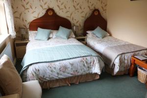 a bedroom with two beds and a table at Comeragh View in Dungarvan