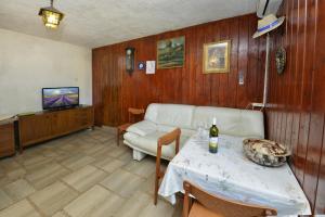 Sala de estar con sofá y mesa con botella de vino en Villa Funtana, en Funtana