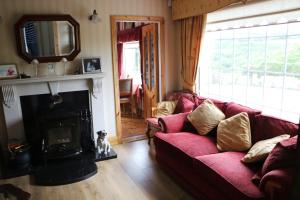 a living room with a red couch and a fireplace at Comeragh View in Dungarvan