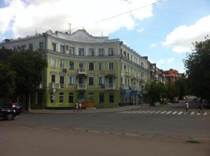 a large yellow building with people walking in front of it at VIP apartment Karl Marks Avenue in Kryvyi Rih