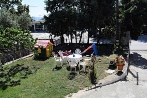 a backyard with a table and chairs and a playground at Palio Villa in Paleo Tsifliki