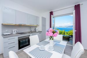 a kitchen with a table with a vase of flowers at Villa Niki 2 in Cavtat