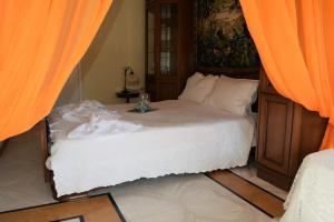 a bedroom with a bed with orange curtains at Palio Villa in Paleo Tsifliki