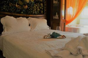 a bed with a tray of food and wine glasses on it at Palio Villa in Paleo Tsifliki