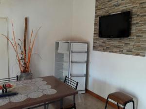 comedor con mesa y TV en la pared en Alojamiento Doña Zule, en San José