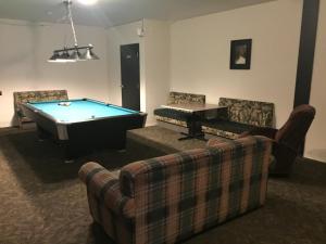 a living room with a pool table and couches at Invermere Hostel in Invermere