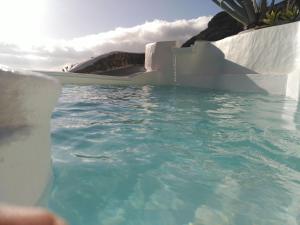 a swimming pool with blue water in the ocean at Vilna House with private pool, jacuzzi and garden -Optional pool and jacuzzi heating in Agaete